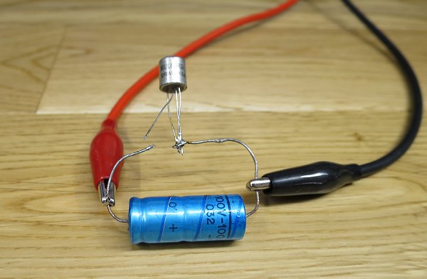 An AF11x soldered to the capacitor, about to be zapped